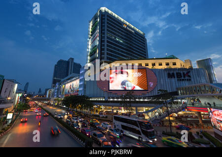 Vista panoramica del traffico su occupato Phayathai Road e MBK Centre shopping mall e altri edifici nel centro cittadino di Bangkok, Thailandia, al tramonto. Foto Stock