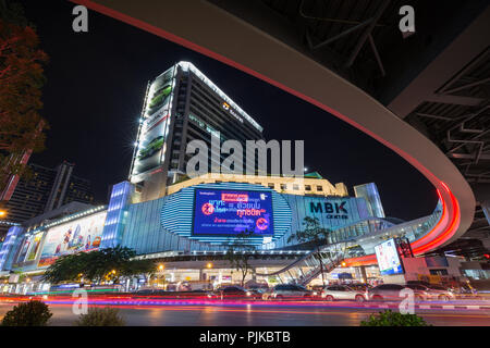 Inceppamento di traffico su occupato Phayathai Road e MBK Centre shopping mall e altri edifici nel centro cittadino di Bangkok, Thailandia, di notte. Foto Stock