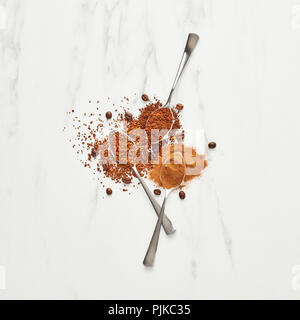 Concetto di caffè. Piatto di laici cucchiai con la massa e il caffè istantaneo su sfondo marmo. Vista superiore, quadrato raccolto. Foto Stock