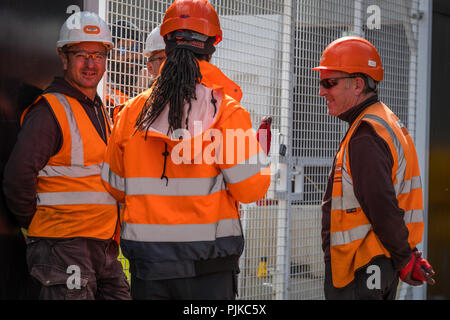 Lavoratori edili di indossare abbigliamento protettivo in discussione. Foto Stock