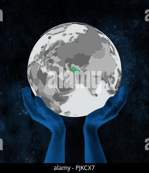 Turkmenistan con bandiera sul globo terrestre in mani nello spazio. 3D'illustrazione. Foto Stock