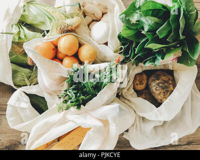 Ortaggi freschi in eco borse in cotone sul tavolo in cucina. la lattuga, mais, patate, albicocche, banane, rucola, funghi dal mercato. rifiuti zero sho Foto Stock