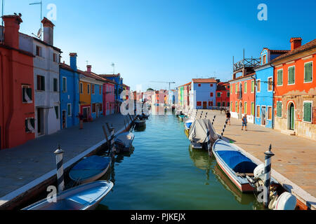 Barche e case colorate in estate Burano, Italia Foto Stock