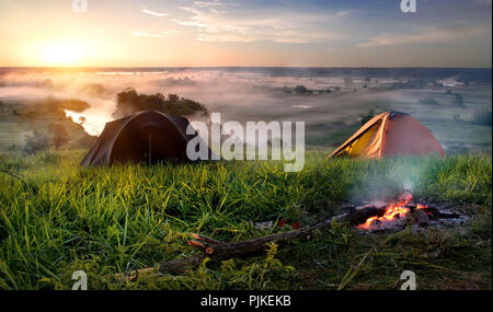 Tende e falò nella steppa vicino al fiume di sunrise Foto Stock