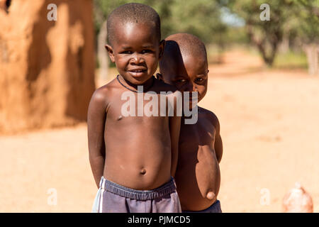 Due ragazzi Himba cercando timido e curioso nella fotocamera Foto Stock
