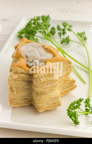 Albero di natale formato vol-au-vent riempito con ragù di funghi su una piastra bianca Foto Stock