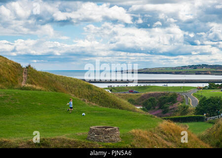 Tynemouth, Inghilterra - Agosto 2, 2018: un ragazzo felicemente giocando a calcio nei pressi di Tynemouth Priory e Castello. Foto Stock