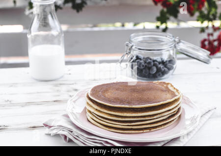 Una delizia prima colazione con frutta fresca su party in giardino, al di fuori di fiori dietro e erbe aromatiche fresche sulla parte superiore Foto Stock