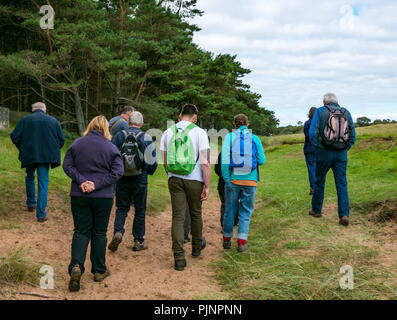 John Muir Country Park, Dunbar, East Lothian, Scozia, Regno Unito, 8 settembre 2018. Un piccolo gruppo di persone godono di una passeggiata e parlare di David Connelly di East Lothian Consiglio Servizio di Archeologia di esaminare la prova di un anno 8000 vecchio tsunami, una riscoperta del Neolitico insediamento agricolo e guerra mondiale le posizioni difensive nel corso di East Lothian Archeologia e Storia locale a quindici giorni che prende si svolge nel mese di settembre di ogni anno e fa parte di quella annuale Archeologia scozzese al mese. Una gamma di passeggiate, colloqui e manifestazioni hanno luogo in East Lothian durante il periodo di due settimane Foto Stock