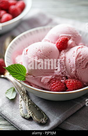 Organico in casa gelato al lampone scoop nel recipiente Foto Stock