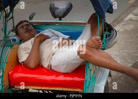 L'uomo addormentato nella sua cycle rickshaw, Yogyakarta, Java, Indonesia. Foto Stock