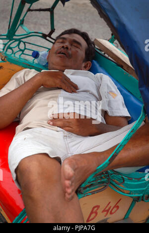 L'uomo addormentato nella sua cycle rickshaw, Yogyakarta, Java, Indonesia. Foto Stock