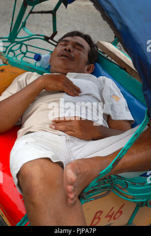 L'uomo addormentato nella sua cycle rickshaw, Yogyakarta, Java, Indonesia. Foto Stock