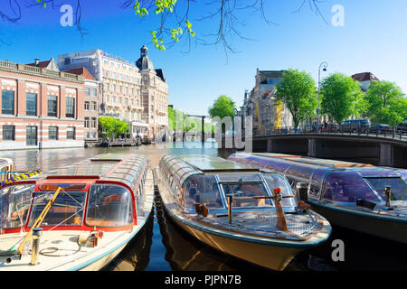Canale nel centro di Amsterdam con la torre Munt, Paesi Bassi Foto Stock