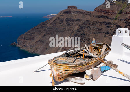 Ld rotto in legno barca sul tetto di casa, situata a Santorini Island, Grecia Foto Stock