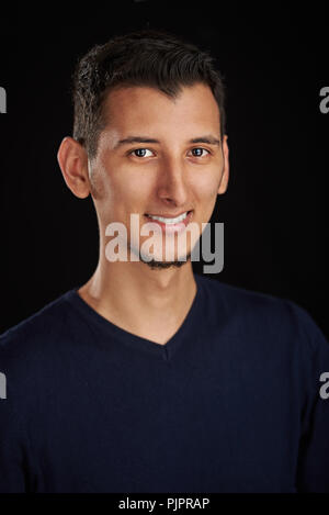 Ritratto di giovane uomo latino isolato su sfondo nero Foto Stock