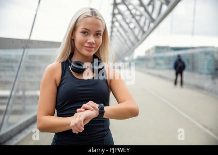 Femmina pareggiatore urbano controllo Smartwatch Tracker sul ponte Foto Stock