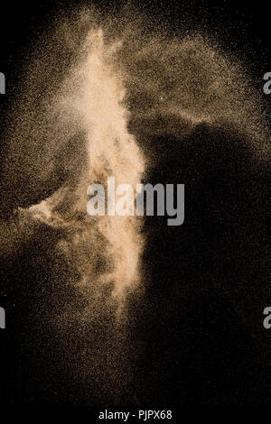 Abstract sabbia di fiume cloud. Golden sabbia colorata splash su sfondo nero. Giallo sabbia volare onda nell'aria. Foto Stock
