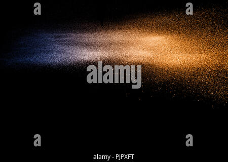 Blu Arancione le particelle di polvere esplosione su sfondo nero. Colore polvere splash. Foto Stock