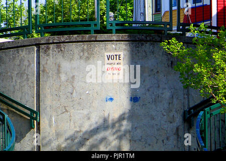 Scala di cemento e di statue in downtown San Giovanni, Terranova, Canada. "Votare persone stanno morendo" segno. Foto Stock