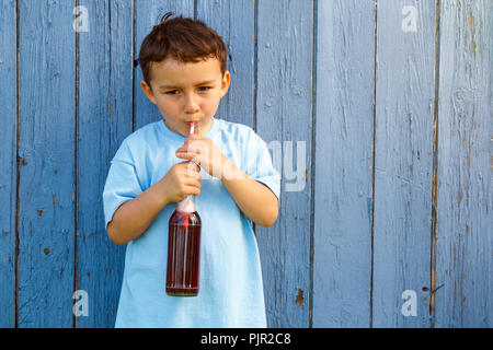 Bambino kid ragazzino bere limonata drink all'aperto all'aperto al di fuori di bottiglia Foto Stock