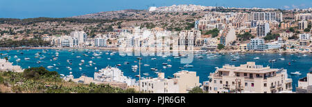 Molte barche, cabinati e barche a remi in Xemxija Bay, Malta. Foto Stock