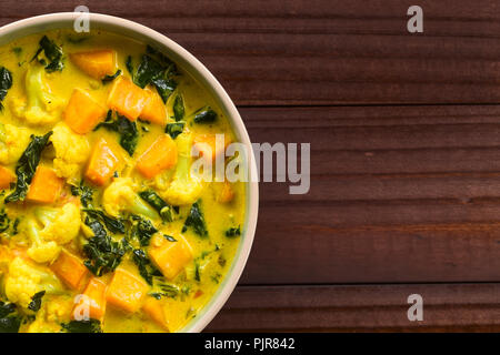 In casa indiano vegetariano zucca di cavolfiore e spinaci curry nella ciotola, fotografato il sovraccarico con copia spazio sul lato (messa a fuoco selettiva) Foto Stock