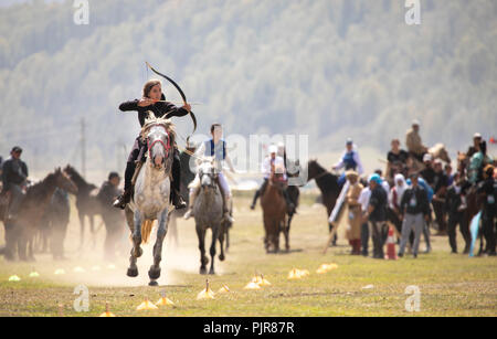 Il lago di Issyk-Kul, Kirghizistan, 6 Settembre 2018: Donna competere nel tiro con l'arco a cavallo gioco Foto Stock