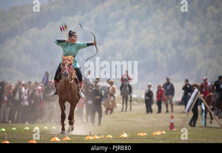 Il lago di Issyk-Kul, Kirghizistan, 6 Settembre 2018: Donna competere nel tiro con l'arco a cavallo gioco Foto Stock