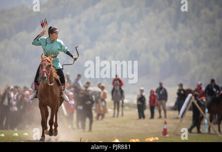 Il lago di Issyk-Kul, Kirghizistan, 6 Settembre 2018: Donna competere nel tiro con l'arco a cavallo gioco Foto Stock