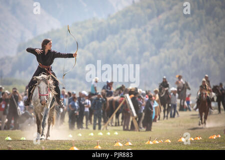 Il lago di Issyk-Kul, Kirghizistan, 6 Settembre 2018: Donna competere nel tiro con l'arco a cavallo gioco Foto Stock