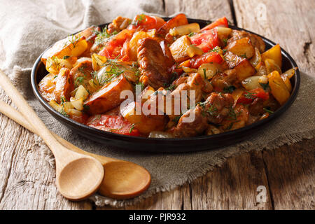 Ojahuri carne fritta con patate, pomodori, cipolle, erbe aromatiche e spezie close-up è servita sul tavolo orizzontale. Foto Stock