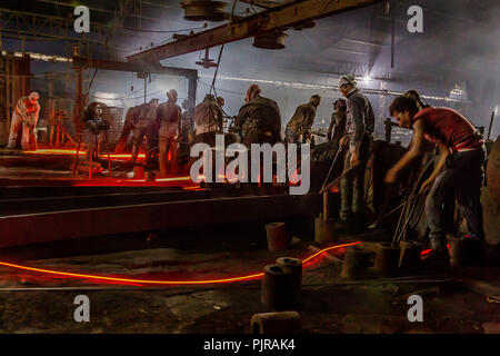 Indian i lavoratori industriali lavorando duro in situazione difficile in fonderia. Foto Stock