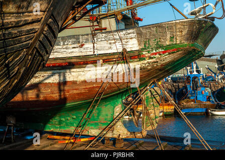 La poppa di una vecchia barca da pesca sotto la riparazione su un molo del porto di Essaouira in Marocco Foto Stock