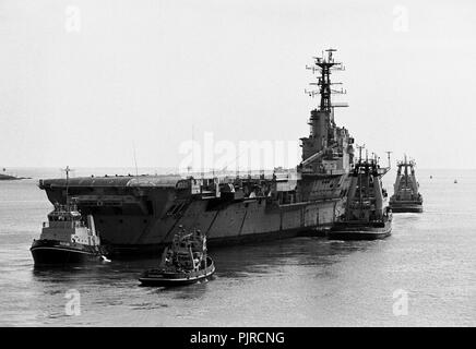 AJAXNETPHOTO. 1984. PORTSMOUTH, ENLAND. - SCRAPYARD legato - la portaerei HMS baluardo trainato fuori della base navale per il cantiere di scarto nel 1984. Foto:JONATHAN EASTLAND/AJAX. REF:HDN(NA)AC/baluardo 100484 31A. Foto Stock