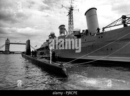 AJAXNETPHOTO. 9 Giugno, 1985. Londra, Inghilterra. - Lasciare Londra - sommergibile HMS OLYMPUS lascia il suo posto barca accanto il Museo CRUISER HMS Belfast dopo una visita di cortesia per la città. Foto:JONATHAN EASTLAND/AJAX. REF:HDD OLYMPUS 1985 9 850906 Foto Stock