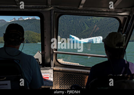 Vista dalla cabina di pilotaggio di un jet boat di un gigante di ghiaccio berg galleggianti in Frederick Sound vicino alla bocca del lecont Bay in Isola di San Pietroburgo, Alaska. L iceberg partorito fuori il vicino ghiacciaio LeConte che è la più meridionale la tidewater ghiacciaio dell'emisfero settentrionale. Foto Stock