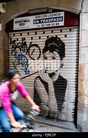 Barcellona arte di strada di Audrey Hepburn con ciclista oltrepassando Foto Stock