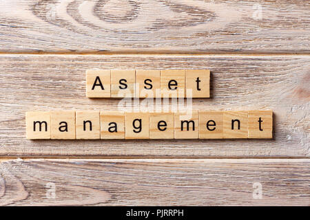 Asset Management parola scritta sul blocco di legno. Gestione degli asset del testo in tabella, concetto. Foto Stock