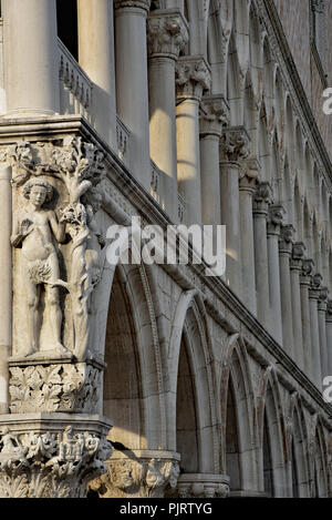 La sera presto luce mette in evidenza questa scultura di Adamo ed Eva con il serpente sull'angolo del Palazzo Ducale di Venezia. L'Europa. Foto Stock