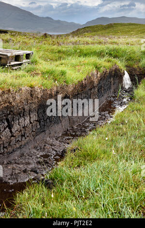 Trench tagliato in profondità la torba e la conservazione delle zone umide mori presso Drinan sull isola di Skye in Scozia con il Loch Slap per l'acqua di scarico per il raccolto Foto Stock