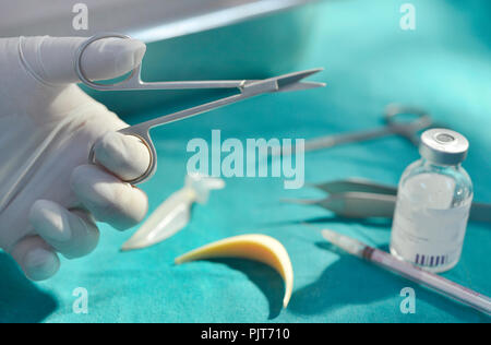 Close up mano azienda strumenti chirurgici in sala operatoria. Foto Stock