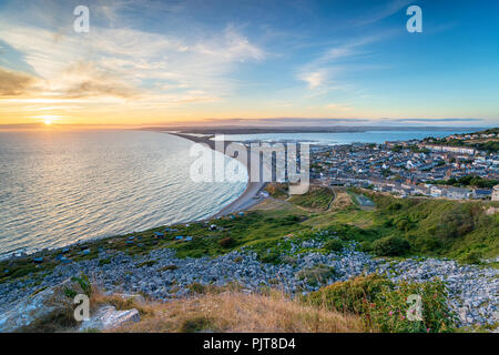 Tramonto sulla causeway sull'isola di Portland vicino a Weymouth su la costa del Dorset Foto Stock