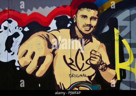 Il vecchio muro dipinto in colore disegno graffiti con vernici spray. L'immagine del famoso giovane pugile Ucraino - Oleksandr Usyk Foto Stock