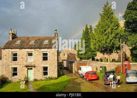 Yorkshire Dales, UK. 9 Settembre 2018: una naturale Rainbow oltre il parco nazionale di villaggio rurale e St Georges bandiera. Clifford Norton Alamy Live News. Foto Stock