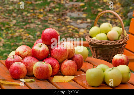 Le mele rosse sul tavolo in giardino Foto Stock