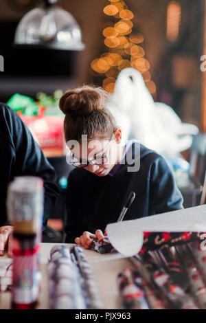 Ragazza impacchettare i regali di Natale Foto Stock