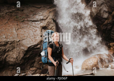 Escursionista di fronte alla cascata, Annapurna circuito, l'Himalaya, Manang, Nepal Foto Stock