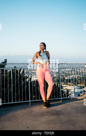 Donna appoggiata contro le ringhiere sulla collina, Los Angeles, US Foto Stock