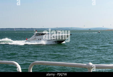 Un cabinato a velocità sul Solent con uno sfondo dell'Isola di Wight, England, Regno Unito Foto Stock